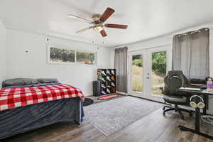 Bedroom featuring french doors, access to exterior, wood finished floors, ceiling fan, and an office area