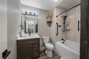 Full bath featuring wood finished floors, vanity, and shower / tub combination