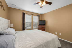 Bedroom with dark colored carpet and ceiling fan