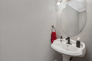 Bathroom featuring ornamental molding and a sink