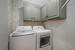 Laundry area featuring washer and clothes dryer and cabinet space