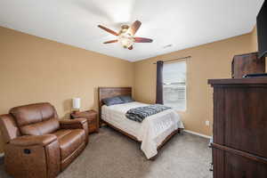Carpeted bedroom featuring baseboards and ceiling fan