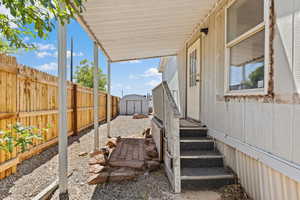 Fenced backyard featuring a storage unit