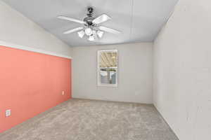 Carpeted spare room with a ceiling fan