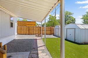 View of yard featuring a storage shed and a patio area