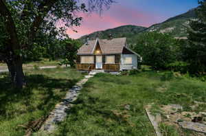 Rustic home with a chimney, a mountain view, and a shingled roof