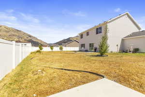 Fenced backyard featuring a patio area and a mountain view