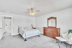 Primary Bedroom featuring light colored carpet and ceiling fan