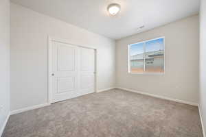 Unfurnished bedroom featuring carpet flooring and a closet