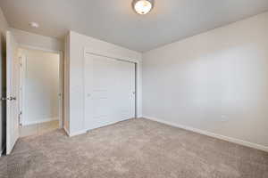 Unfurnished bedroom with carpet and a closet