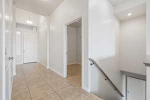 Hallway with an upstairs landing and light tile patterned flooring