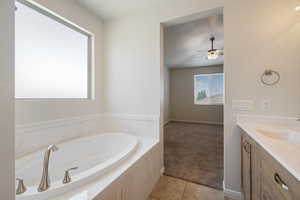 Bathroom featuring a bath, tile patterned floors, ceiling fan, and vanity