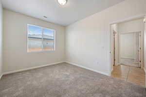 Empty room featuring light carpet and baseboards