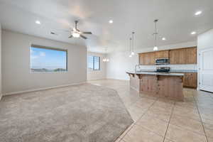 Kitchen featuring ceiling fan, recessed lighting, a breakfast bar, open floor plan, and light tile patterned floors