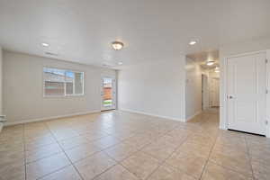 Unfurnished room with light tile patterned floors and recessed lighting