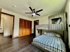 Bedroom with wood finished floors, a closet, ceiling fan, and a textured ceiling