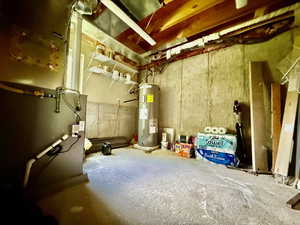 Unfinished basement featuring heating unit and water heater