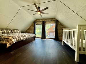 Bedroom featuring wood finished floors, lofted ceiling, a ceiling fan, and a textured ceiling