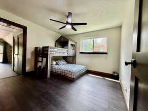 Bedroom with wood finished floors, a textured ceiling, and ceiling fan