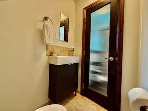Half bathroom featuring tile patterned floors and vanity