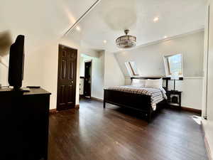 Bedroom with lofted ceiling, dark wood-style flooring, and recessed lighting