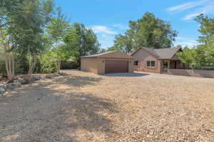 View of front of property featuring concrete driveway, an attached garage, stucco siding, roof with shingles, and brick siding