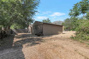View of property exterior with a mountain view, stucco siding, and an outbuilding
