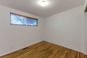 Unfurnished room featuring wood finished floors and baseboards