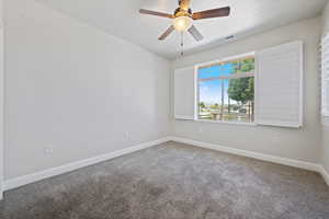 Empty room with carpet floors, a textured ceiling, and ceiling fan