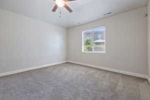 Empty room featuring ceiling fan and carpet