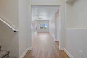 Hall with light wood-style flooring and stairs