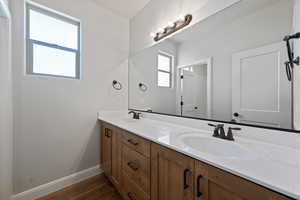 Bathroom with double vanity and wood finished floors