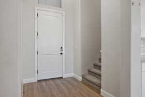 Entryway with wood finished floors and stairs