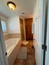 Full bath with a shower stall, a garden tub, tile patterned flooring, and a textured ceiling