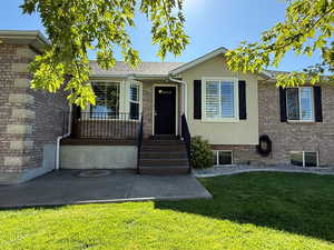 View of front facade featuring a front yard, brick siding, and stucco siding