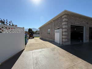 View of side of property with a mountain view, brick siding, and concrete driveway