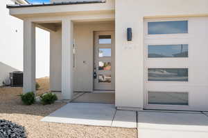 Doorway to property featuring stucco siding