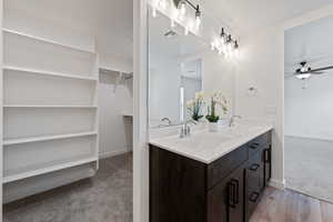 Bathroom featuring a ceiling fan and double vanity