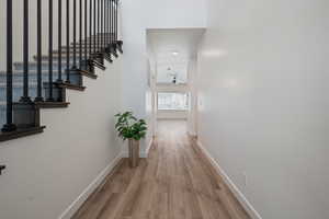 Corridor with wood finished floors and stairway