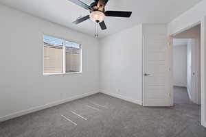 Unfurnished room featuring carpet flooring and ceiling fan