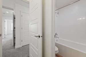 Bathroom featuring toilet and bathtub / shower combination