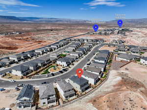 Aerial view of property and surrounding area featuring mountains and nearby suburban area