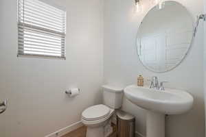 Half bathroom with baseboards and wood finished floors