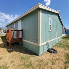 View of property exterior with a deck and a yard