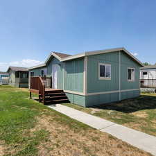 Manufactured / mobile home featuring a deck and a front yard