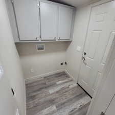 Washroom with cabinet space, light wood-style flooring, washer hookup, and electric dryer hookup