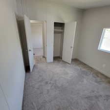 Unfurnished bedroom featuring light colored carpet and a closet