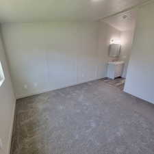 Unfurnished bedroom featuring carpet floors and ensuite bath