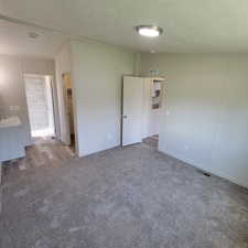 Carpeted empty room with a textured ceiling