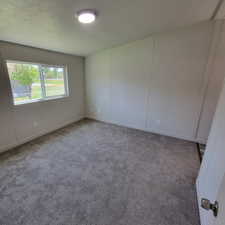 Unfurnished room with carpet flooring and baseboards